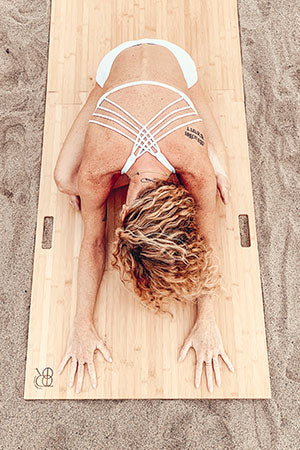 woman on Root Board on sand on beach