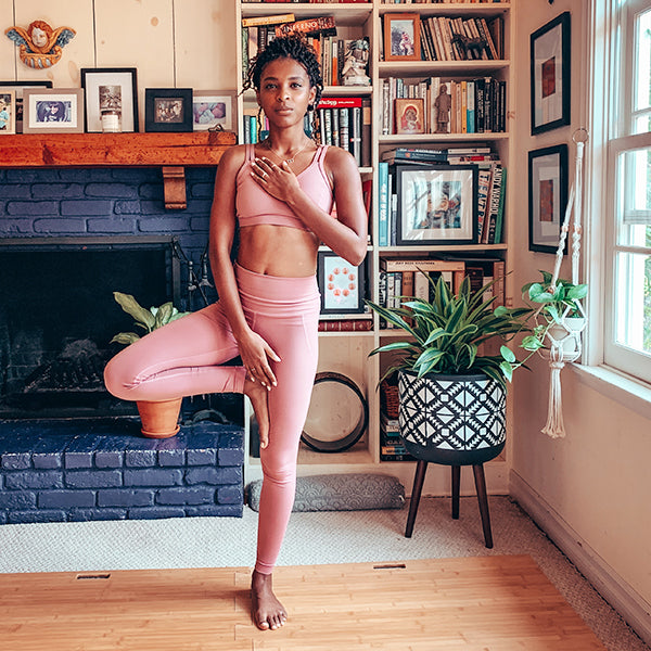 Woman in tree pose on Root Board portable yoga platform on carpet