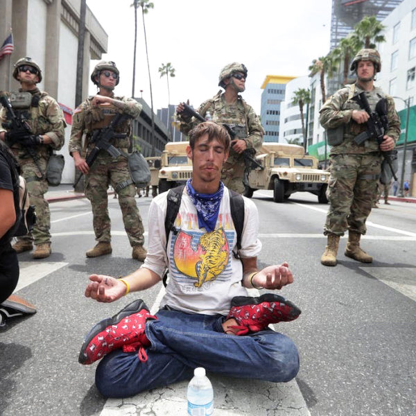 Man meditates in front of Armed Military