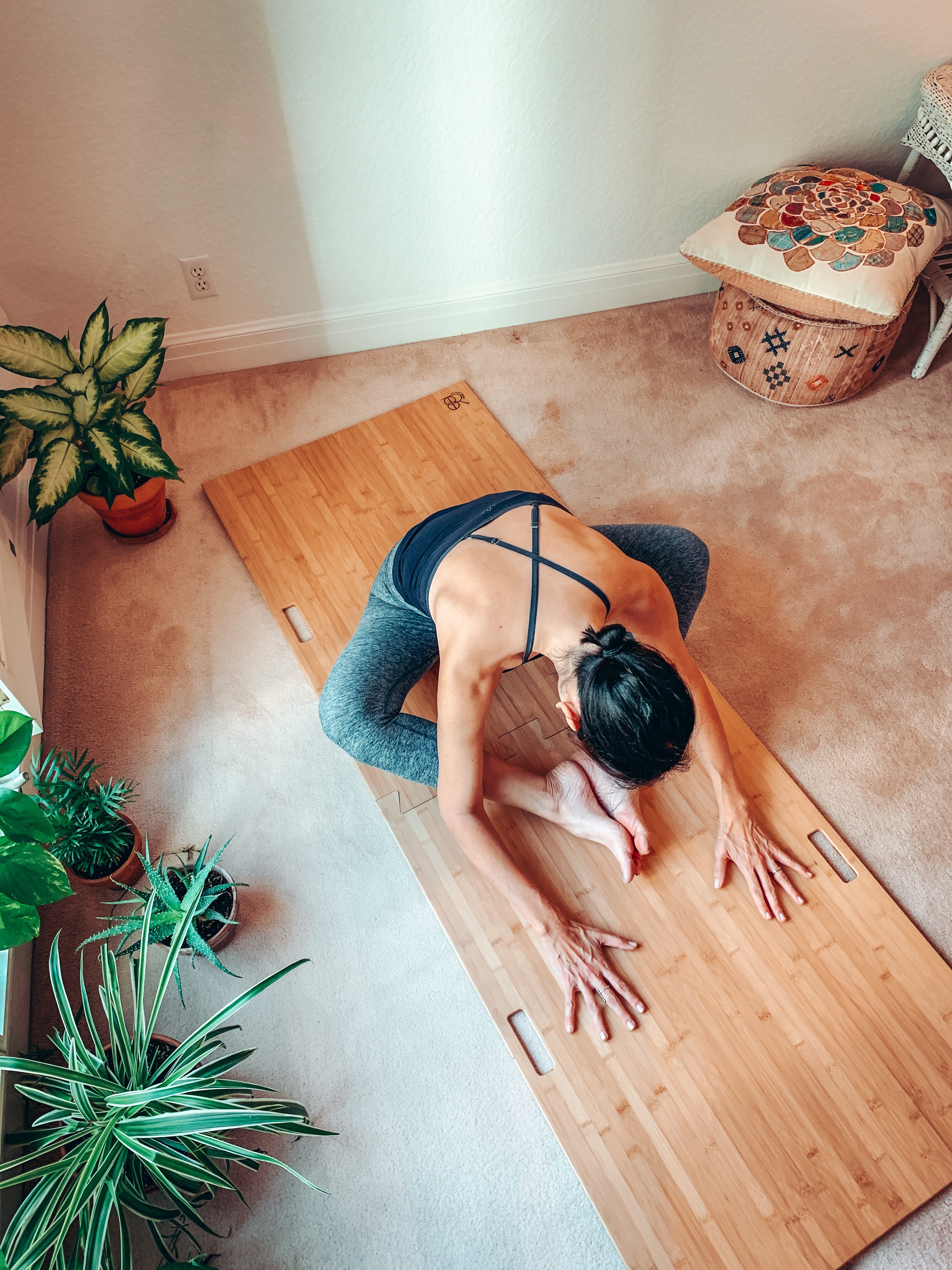 yogi stretches forward on a portable yoga platform